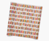 A square sheet of wrapping paper featuring a colorful birthday candle print on a cream background, shown at an angle against a plain white background.