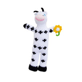 Handknit cow rattle with a yellow flower in its hand, against a white background.