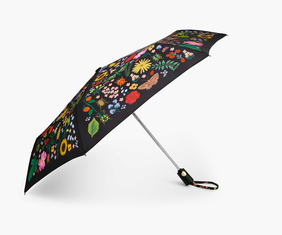 Black open umbrella with curio print, against a white background.