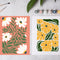 Two colorful floral paintings displayed side by side on a light gray surface, with paintbrushes and small paint tubes nearby. The left print shows white daisies with green leaves on a light coral background, and the right print shows yellow daisies with dark green leaves on a white background. 