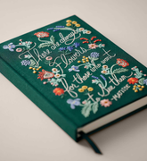 Close up of dark green, floral embroidered journal with the text "There are always flowers for those who want to see them. -Matisse"