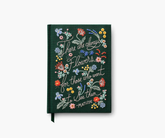 Dark green embroidered notebook with the text "There are always flowers for those who want to see them. -Matisse". Bright colored flowers are embroidered on the journal, laid against a white background.
