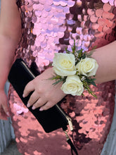 Corsage made with white spray roses, against a rose gold sequin dress.