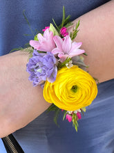 Corsage made in bright colors, against a navy blue suit jacket.