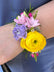 Corsage made in bright colors, against a navy blue suit jacket.