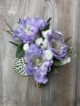Boutonniere made with lavender flowers and greenery.