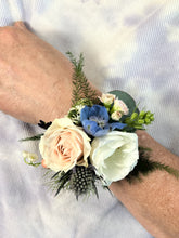 Corsage made in neutral colors against a neutral tie die background. 