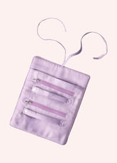 The inside of a travel jewelry roll, with two zippers and a main puch. The fabric is a lilac satin.