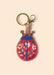 Gold keyring with a beaded blue and hot pink ladybug charm, set against a cream background.