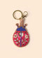Gold keyring with a beaded blue and hot pink ladybug charm, set against a cream background.