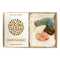 Box with sunstone, tiger's eye, citrine, pyrite, and green adventurine sit against a white background. A white card with a Cast of Stones logo and the text "Prosperity & Abundance Crystals and Stones" sits on the left side of the box. 