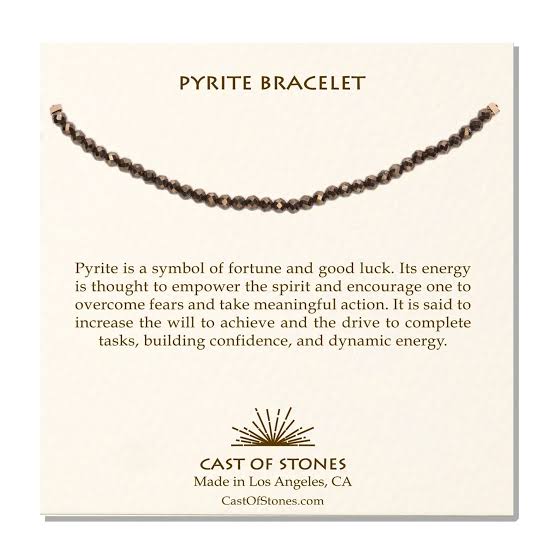 A cream, Cast of Stones branded backing card holds a crystal-beaded bracelet labelled "Pyrite Bracelet". There is an informational paragraph below the bracelet detailing the properties of the crystal and its benefits.