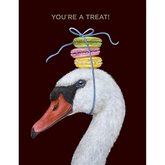 A painting of a swan with macaroons atop its head, in front of a black background. Text above it reads "You're a treat!"