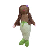 Hand-knit black mermaid rattle with green tail and purple flower in her hair, against a white background.