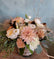 Floral arrangement in a neutral pink and white color palette with whispy greens and accent, in a vase wrapped in a burlap inspired ribbon.