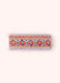 A headband with a geometric orange, purple and gold pattern on it, against a light background.
