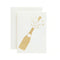 Ivory greeting card with a gold foil cutout of a champagne bottle popping.