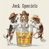 An illustration of a three spaniel dogs wearing cowboy hats and holsters, with a whiskey glass in between them. The middle dog sits in the glass, and the text above them reads "Jack Spaniels".