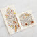 A guest napkin and cocktail napkin lay on a white marble background next to each other. Both napkins are printed with a fall foliage illustration, with the word "Grateful" in brown cursive in the middle. 