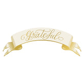 A white banner table setting with the word "Grateful" in gold cursive.