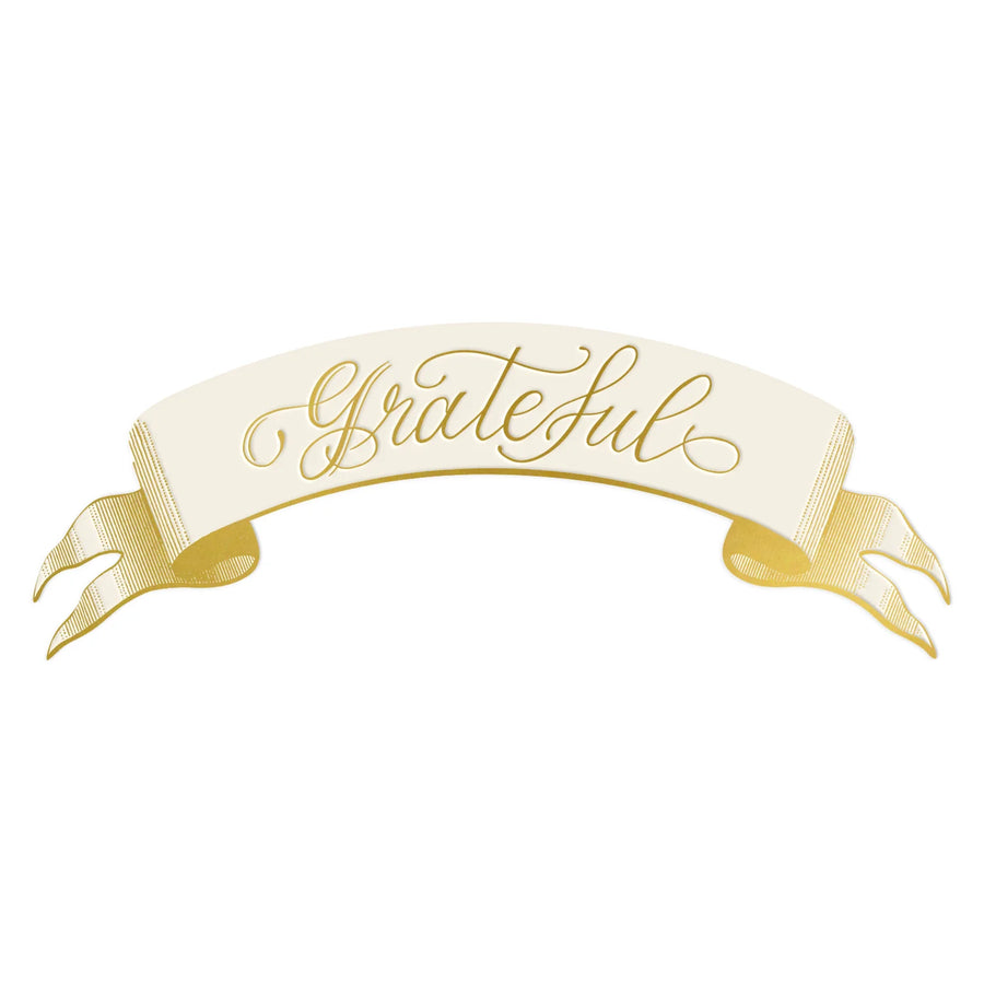 A white banner table setting with the word "Grateful" in gold cursive.