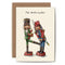 Greeting card with two nutcrackers standing across from the other, the one on the left kicking the other in the nether regions. The card reads "The Nutcracker".