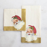 A cocktail napkin and guest napkin stacked next to each other, with gold trim and an illustrated vintage Santa Clause. The napkins are laid on a white marble background.