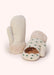 White knitted children's mittens with hedgehogs and green polka dots, against a white background.