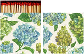 An open matchbook with illustrations of green and blue hydrangeas and matches with red heads poking out of the top. 