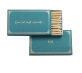 A teal matchbox with the saying "If you can't laugh at yourself...I will."