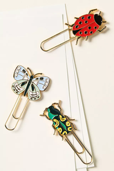 Three insect-shaped paper clips on a white background.