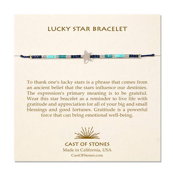 A cream, Cast of Stones-branded backing card holds a crystal-beaded bracelet labelled "Lucky Star Bracelet". There is an informational paragraph below the bracelet.