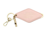 A baby pink diamond-shaped leather keychain with a brass key ring, split ring, and whistle. Engraved on the keychain is the phrase "Some days I wish I had more middle fingers."