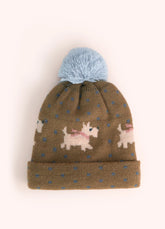 A light brown children's knit hat with orange highland cows, white westies, blue polka dots, and a powder blue pompom on the top, against a white background.