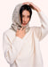 A woman in a cream sweater wearing a Scandinavian inspired snood head piece, with a simple cream and sage green floral pattern. 