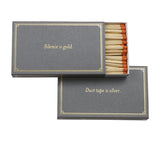 Dark grey matchbox with the saying "Silence is gold. Duct tape is silver."