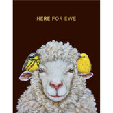 A black card with a painting of a sheep with a yellow bird sitting on each ear. Gold text above it reads "Here for ewe".