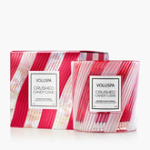 Red and white striped candle with a matching box against a white background.