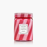 Red and white striped jar candle against a white background.