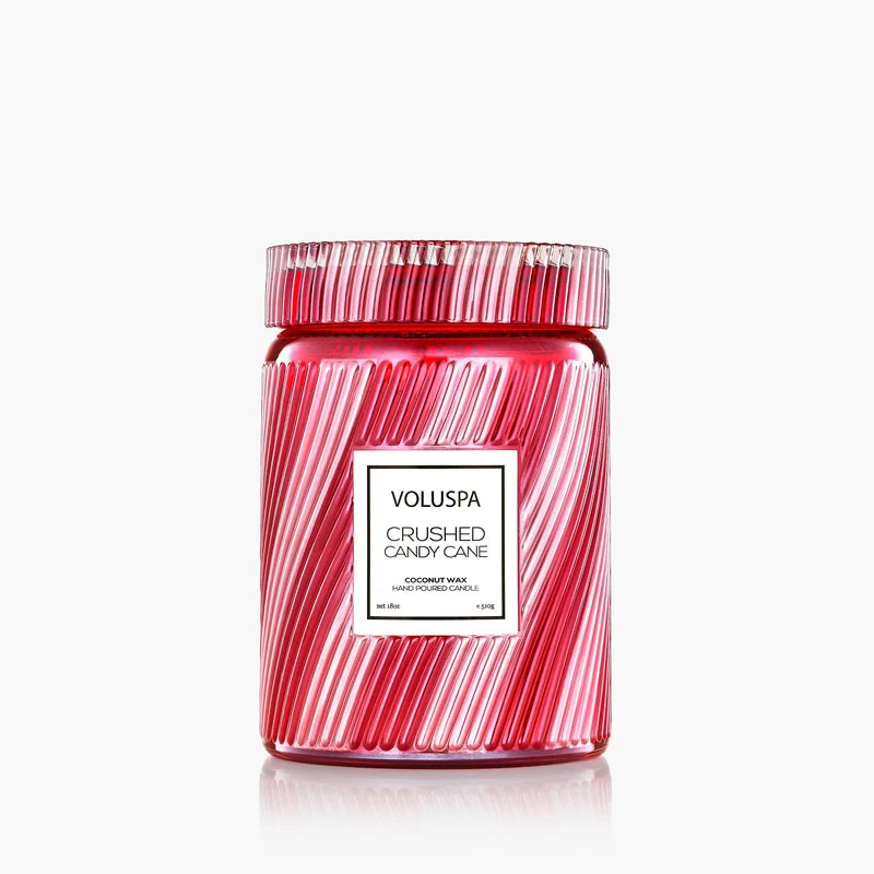 Red and white striped jar candle against a white background.