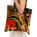 A person holds a canvas tote bag featuring a detailed print of an owl, red mushrooms, and green foliage against a dark background.