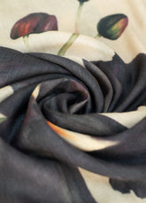 Close up of a wool scarf swirled into itself, in beige, dark purple and green.